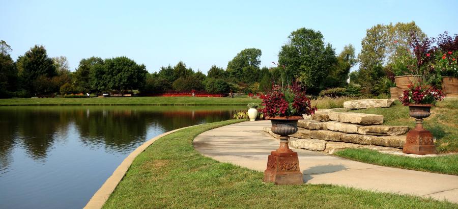 Sun shines on a pond and walkway in Overland Park's arboretum. 