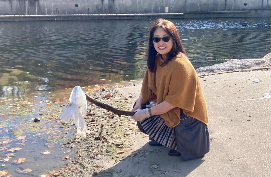 Plog cleanup volunteer with stick and plastic bag.