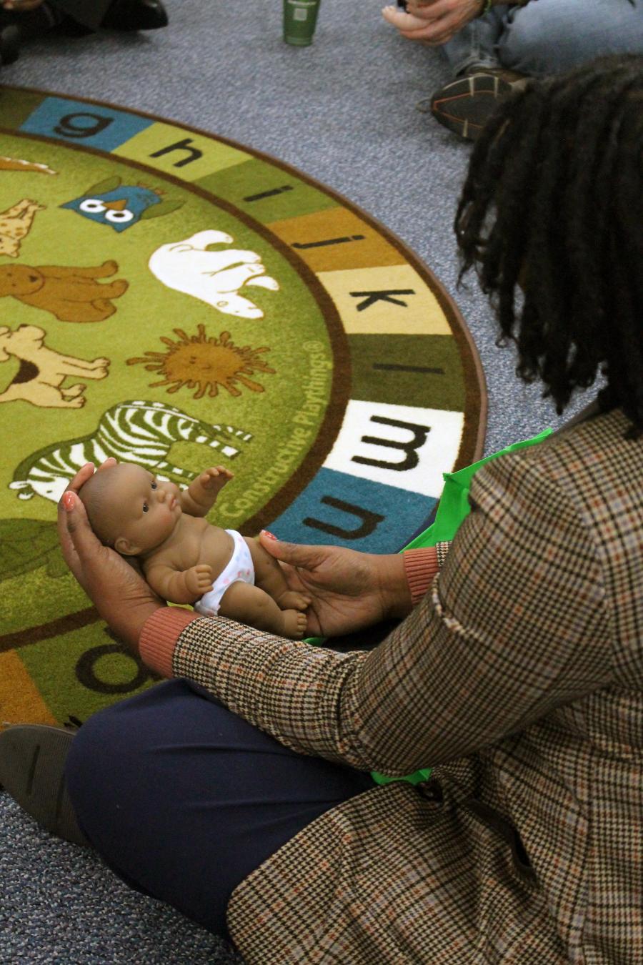 A woman participates in Baby Circle Time at the Seeds of Change recruitment event.