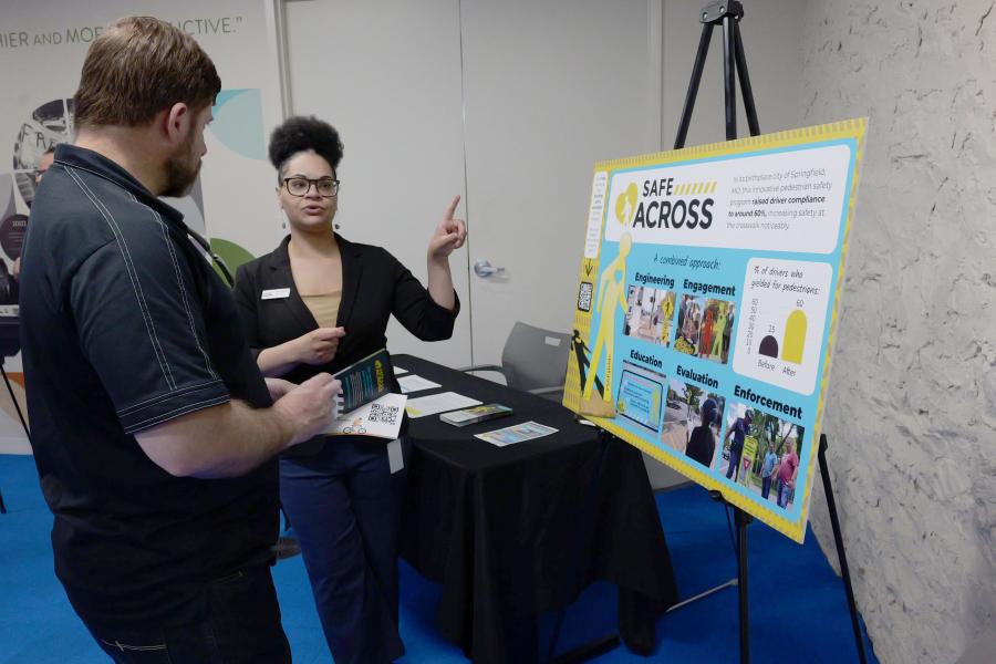 Person talking to attendee about SafeAcross