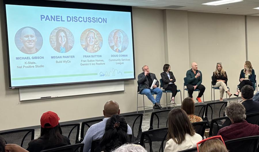 Panelists seated during a housing discussion event